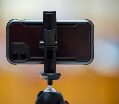 A mobile phone mounted on a tripod for teaching students online.