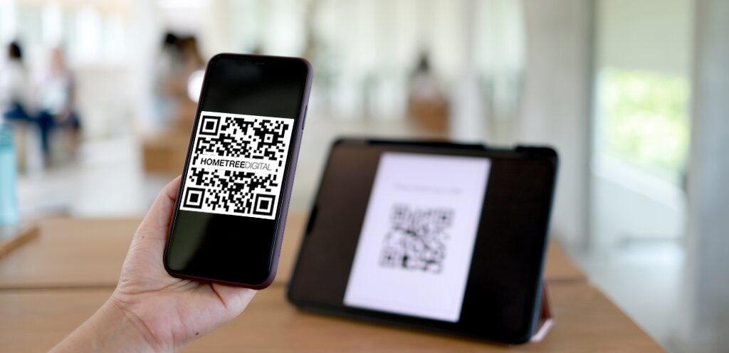 Hand holding an iPhone with a QR code onscreen.