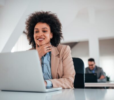 smiling woman on laptop on office